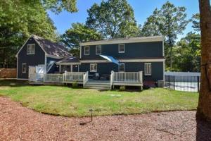 una casa azul con dos bancos delante en Contemporary Gem with Private Pool, en Barnstable