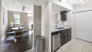 a kitchen with a sink and a table with a dining room at Landing Modern Apartment with Amazing Amenities (ID4287X36) in Orlando