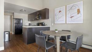 Landing Modern Apartment with Amazing Amenities (ID9230X68) في لونغمونت: مطبخ وغرفة طعام مع طاولة وكراسي