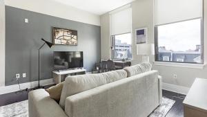 ein Wohnzimmer mit einem Sofa und einem TV in der Unterkunft Landing Modern Apartment with Amazing Amenities (ID1239X428) in Richmond