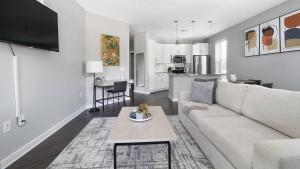 a white living room with a couch and a table at Landing Modern Apartment with Amazing Amenities (ID1358X777) in Chapel Hill