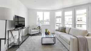 a white living room with a couch and a tv at Landing Modern Apartment with Amazing Amenities (ID5395X21) in Portland