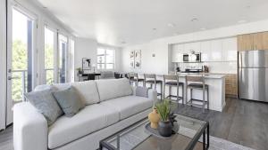 a living room with a white couch and a kitchen at Landing Modern Apartment with Amazing Amenities (ID5395X21) in Portland