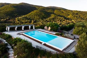 an overhead view of a swimming pool with mountains in the background at Casagliana Suite Resort in Olbia