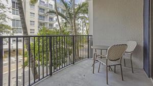 a balcony with two chairs and a table and a palm tree at Landing Modern Apartment with Amazing Amenities (ID7763) in Fort Lauderdale