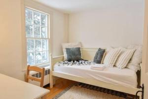 a white bed in a room with a window at Featured in Cape Cod Life Magazine in Barnstable