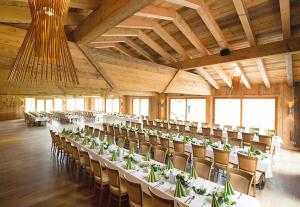 un gran salón de banquetes con mesas y sillas. en Landgasthof Schmuck, en Sauerlach
