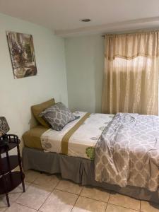 um quarto com uma cama e uma janela em 24511 149th Road Rosedale em Rosedale