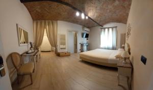 La Corte Country Rooms في مودينا: غرفة نوم كبيرة بسرير وجدار حجري