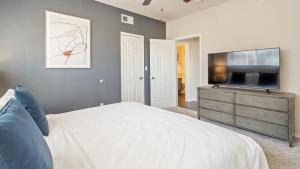 um quarto com uma cama e uma televisão de ecrã plano em Landing Modern Apartment with Amazing Amenities (ID8229X54) em Plano
