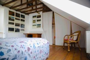 a bedroom with a bed and a chair and a staircase at Villa Eden maison de pêcheur traditionnelle avec jardin in Cayeux-sur-Mer