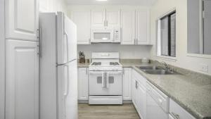 cocina blanca con fogones y fregadero en Landing Modern Apartment with Amazing Amenities (ID1233X125), en Redlands