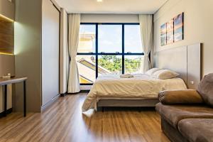 une chambre avec un lit et une grande fenêtre dans l'établissement Studio em condomínio c/ piscina 700m praia STI210, à Florianópolis 17 autres photos