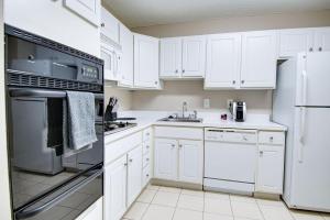 a kitchen with white cabinets and white appliances at Landing Modern Apartment with Amazing Amenities (ID4403X17) 