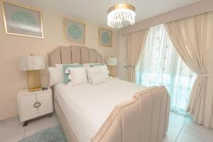 a bedroom with a large white bed and a chandelier at Luxury 3BR Apartment in Astria 908 in Tegucigalpa