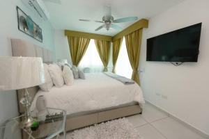 a bedroom with a bed with a ceiling fan and a flat screen tv at Luxury 3BR Apartment in Astria 908 in Tegucigalpa
