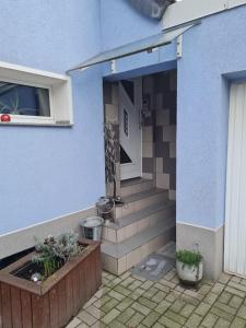 a blue house with stairs and a window and plants at Schnuckelige Wohnung in Marl