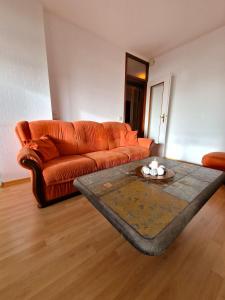an orange couch in a living room with a table at Ferienpark P05-008 Ferienpark in Heiligenhafen