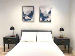 ein Schlafzimmer mit einem Bett mit drei Bildern an der Wand in der Unterkunft Stylish Private Suite with 2 Bedrooms in Midtown in Toronto