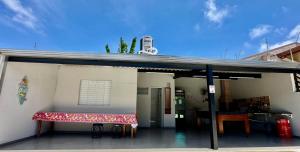 a building with a covered porch with a bench at Casa aconchegante em Peruíbe in Peruíbe