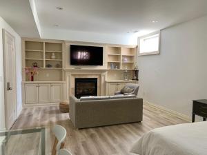 ein Wohnzimmer mit einem Sofa und einem Kamin in der Unterkunft Stylish Private Suite with 2 Bedrooms in Midtown in Toronto