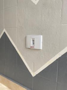 a white switch on a wall in a bathroom at Casa Guarujá próx. Balsa Santos in Guarujá