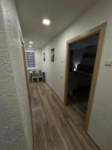 um corredor com uma porta para um quarto com uma cama em Apartments Victoria em Panevėžys