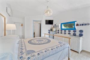 a white bedroom with a bed and a sink at suite paradiso in Quartu SantʼElena