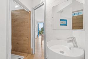 uma casa de banho branca com um lavatório e um espelho em suite paradiso em Quartu SantʼElena