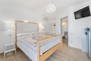 a bedroom with a bed and a tv on a wall at suite paradiso in Quartu SantʼElena