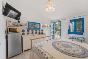 a bedroom with a bed and a tv and a kitchen at suite paradiso in Quartu SantʼElena