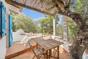 a wooden table and chairs on a patio with a tree at suite paradiso in Quartu SantʼElena