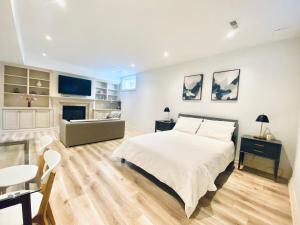 1 dormitorio con cama, mesa y sofá en Stylish Private Suite with 2 Bedrooms in Midtown en Toronto