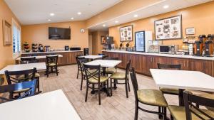 a restaurant with tables and chairs and a bar at Best Western Golden Key in Auburn