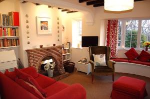 a living room with a red couch and a fireplace at Minafon near Barmouth in Llanaber