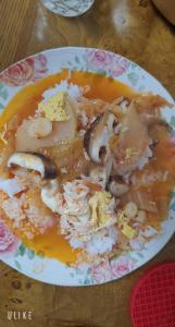 a plate of soup with mushrooms and rice on a table at 천성리버 아파트 집전체 렌트 in Yangsan