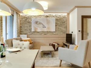 a living room with white furniture and a brick wall at Appartement Courchevel 1550, 3 pièces, 4 personnes - FR-1-562-28 in Courchevel