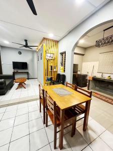 een keuken en een woonkamer met een tafel en stoelen bij MZ Homestay Tuaran in Tuaran