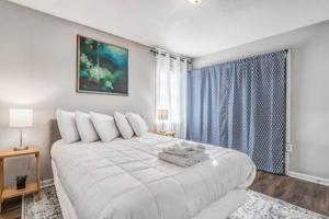 a white bedroom with a large bed and a window at Mins from Parks Hiking & Dining- Brick Bungalow in Memphis
