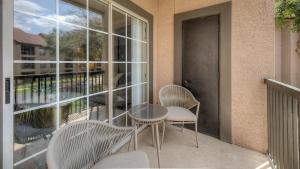 uma varanda com 2 cadeiras, uma mesa e uma janela em Landing Modern Apartment with Amazing Amenities (ID5315) em Fort Worth