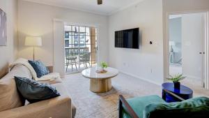 uma sala de estar com um sofá e uma mesa em Landing Modern Apartment with Amazing Amenities (ID5315) em Fort Worth