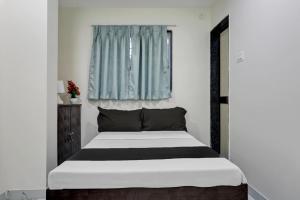een slaapkamer met een groot bed en een raam bij Collection O Casa Inn in Pune