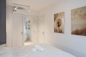a white bedroom with a bed and a mirror at Loft moderno e bem localizado V777312 in Porto Alegre