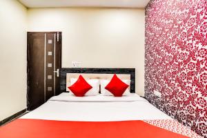 a bedroom with a bed with red pillows at OYO Royal Continental in New Delhi