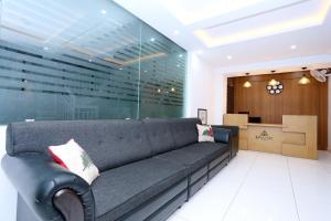 a living room with a gray couch in a lobby at Kings Fort in Cochin