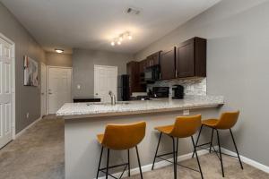 a kitchen with three bar stools at a counter at Landing Modern Apartment with Amazing Amenities (ID4329) in Mount Juliet