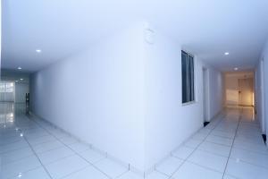 an empty hallway with white walls and white tile floors at Kings Fort in Cochin