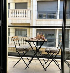 una mesa y dos sillas frente a una ventana en Sol Mediterráneo Palm City, en Elche
