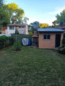 un patio con una casa y una valla en Casa de bosque en el Mar en Santa Teresita