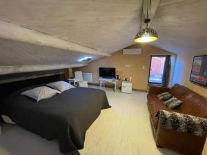 een slaapkamer met een groot bed en een bank bij Le 47 - Rentals in South of France in Beaumont-de-Pertuis